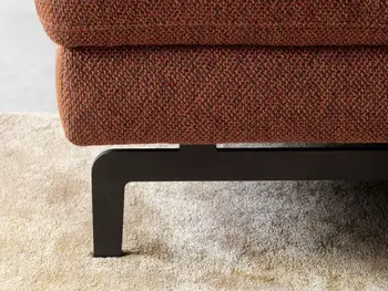 Schwarzes Metallfußgestell eines rostroten Sofas.