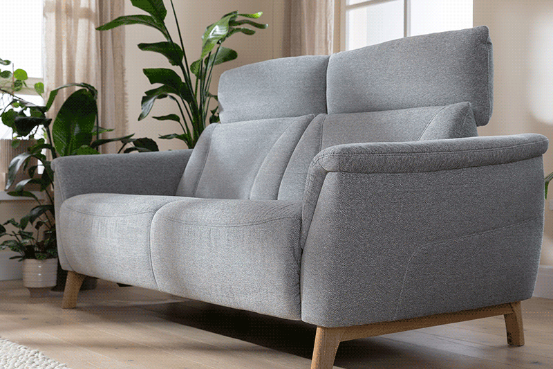 Graues 2-Sitzersofa mit hoher Kopfstütze und motorischem Sitzvorzug.