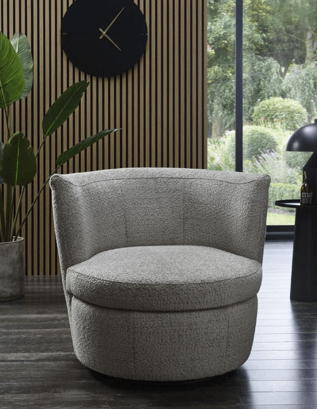 Grauer Bouclesessel, der komplett drehbar ist.