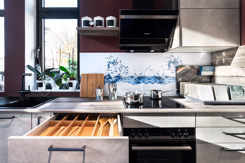 Contur Kuechenzeilein weiss mit offener Schublade und stylischer Dunstabzugshaube.