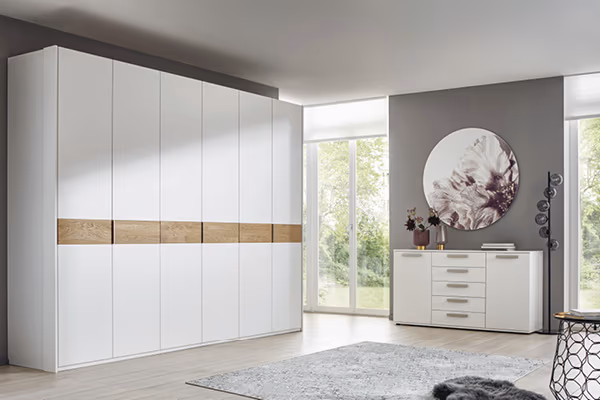Glatte Oberflächen und natürliche Optik durch Elemente aus Holz machen den Kleiderschrank im modernen Schlafzimmer zu einem Highlight.