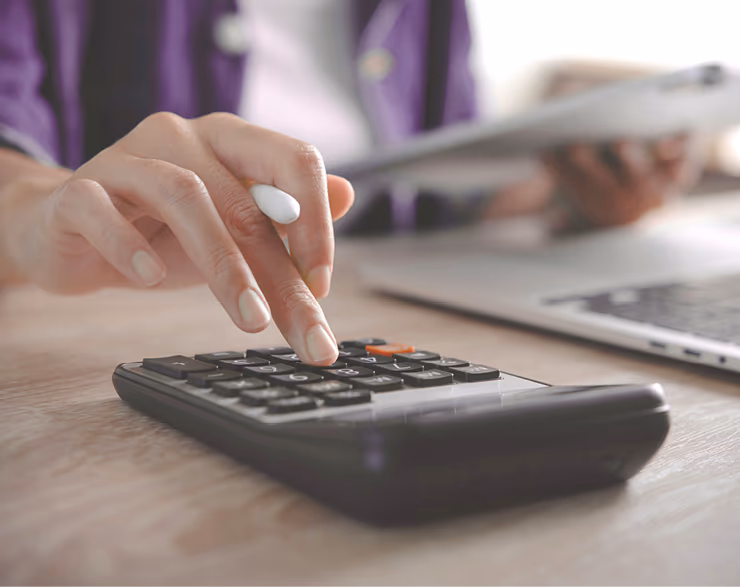 Nahaufnahme einer Hand die Werte in Taschenrechner eingibt