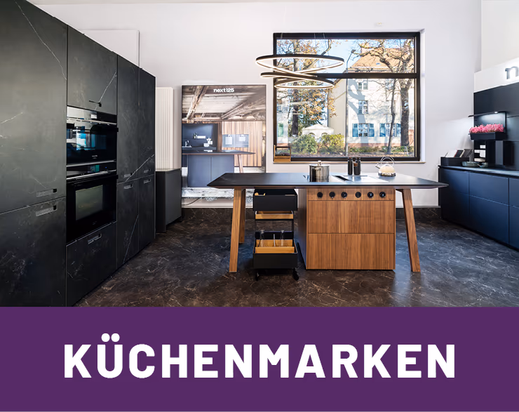 Stylische anthrazitfarbene Next125 Kueche mit hoelzerner Kuecheninsel im Kuechenhaus Gruber