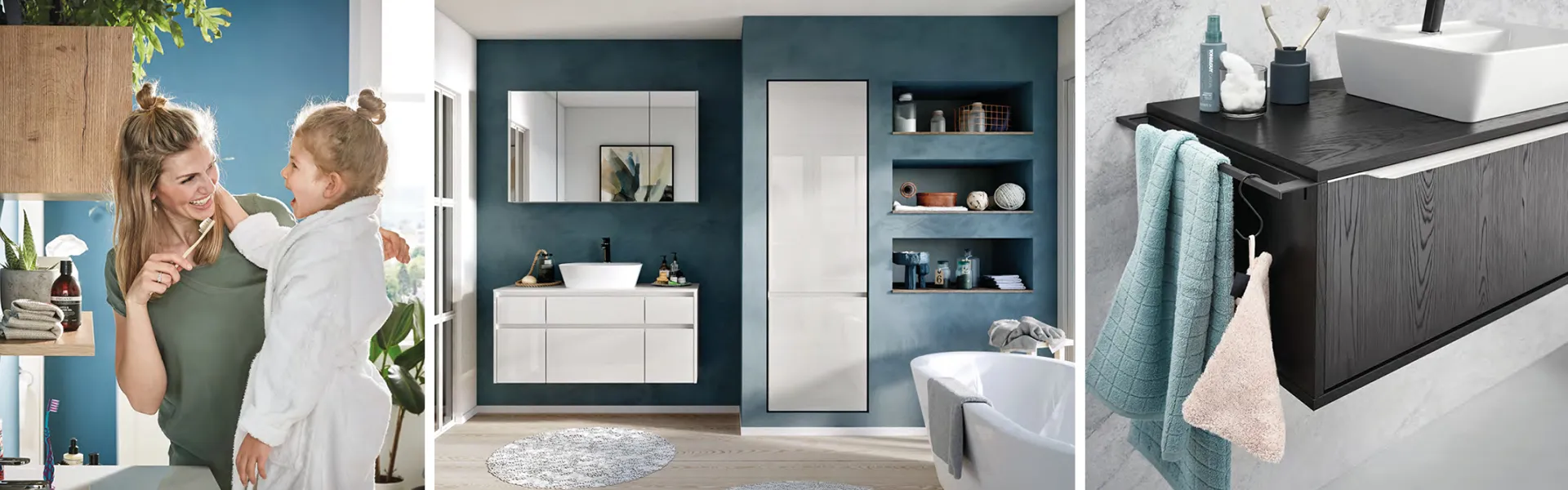 Mutter mit Tochter im Bad beim Zähneputzen, weiße Badmöbel vor blauer Badezimmerwand, blaues Handtuch am dunklen Holzsideboard im Bad