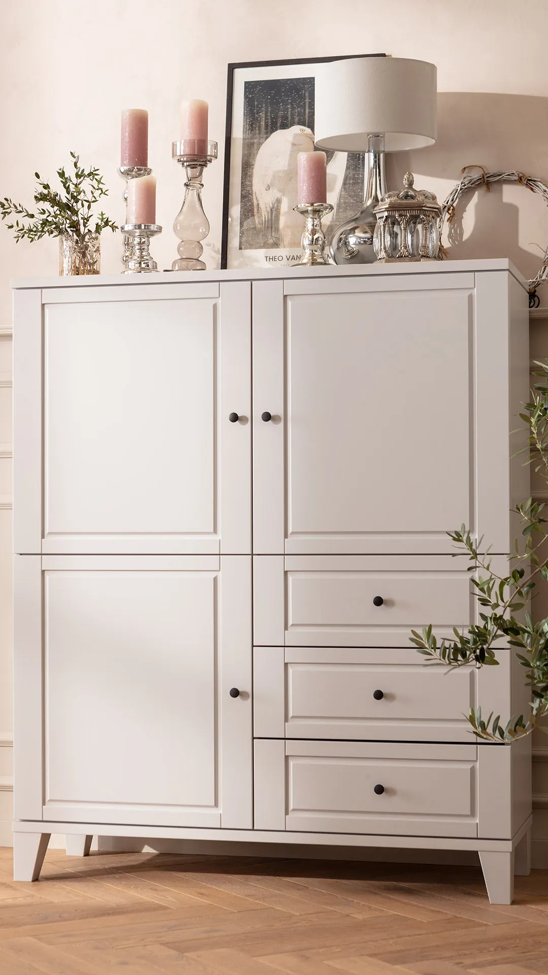 Lebensart Vitrine Stanford mit dekorativen Topfpflanzen und roséfarbenen Kerzen