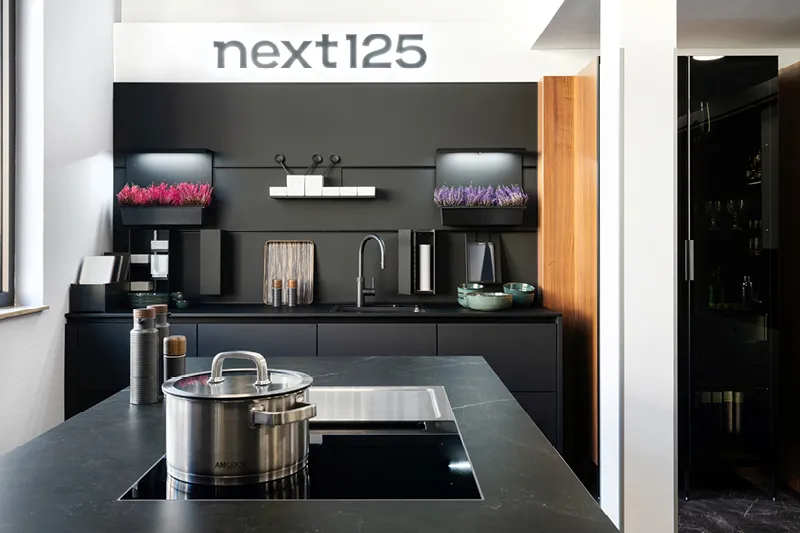 Anthrazitfarbene Inselkueche mit Holzelementen im Kuechenhaus Gruber