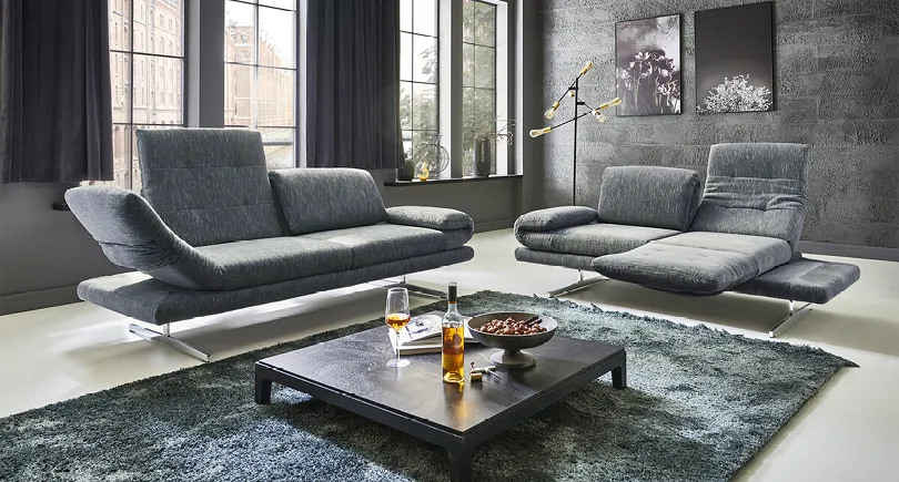 Graues Funktionssofa im modernen Wohnzimmer, dunkel und puristisch