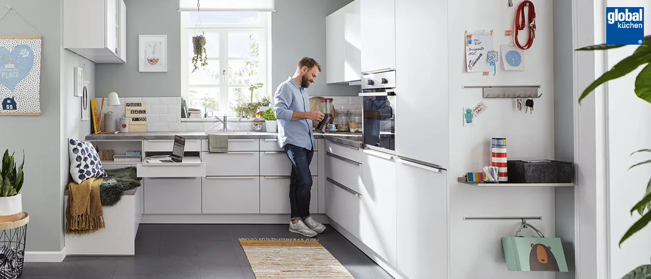 Global Küchen - Mann in moderner weißer Winkelküche