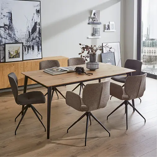 Esstisch aus Holz mit gepolsterten Stühlen im hellen Esszimmer