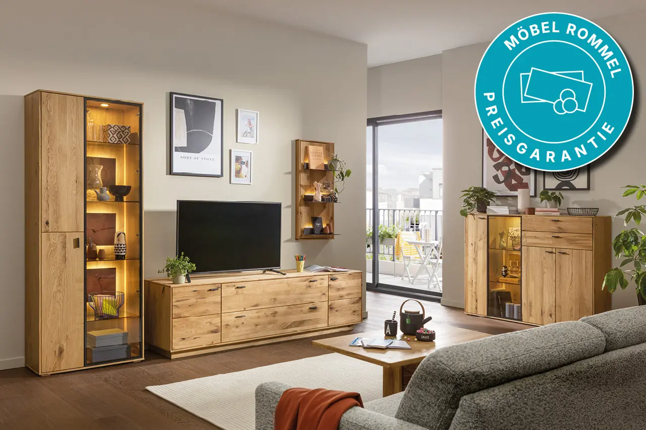 Modern eingerichtetes Wohnzimmer mit Wohnwand, TV Lowboard und Vitrine aus Massivholz, gemütliche Wohnmöbel mit Beleuchtung und Preisgarantie vom Möbelhaus.