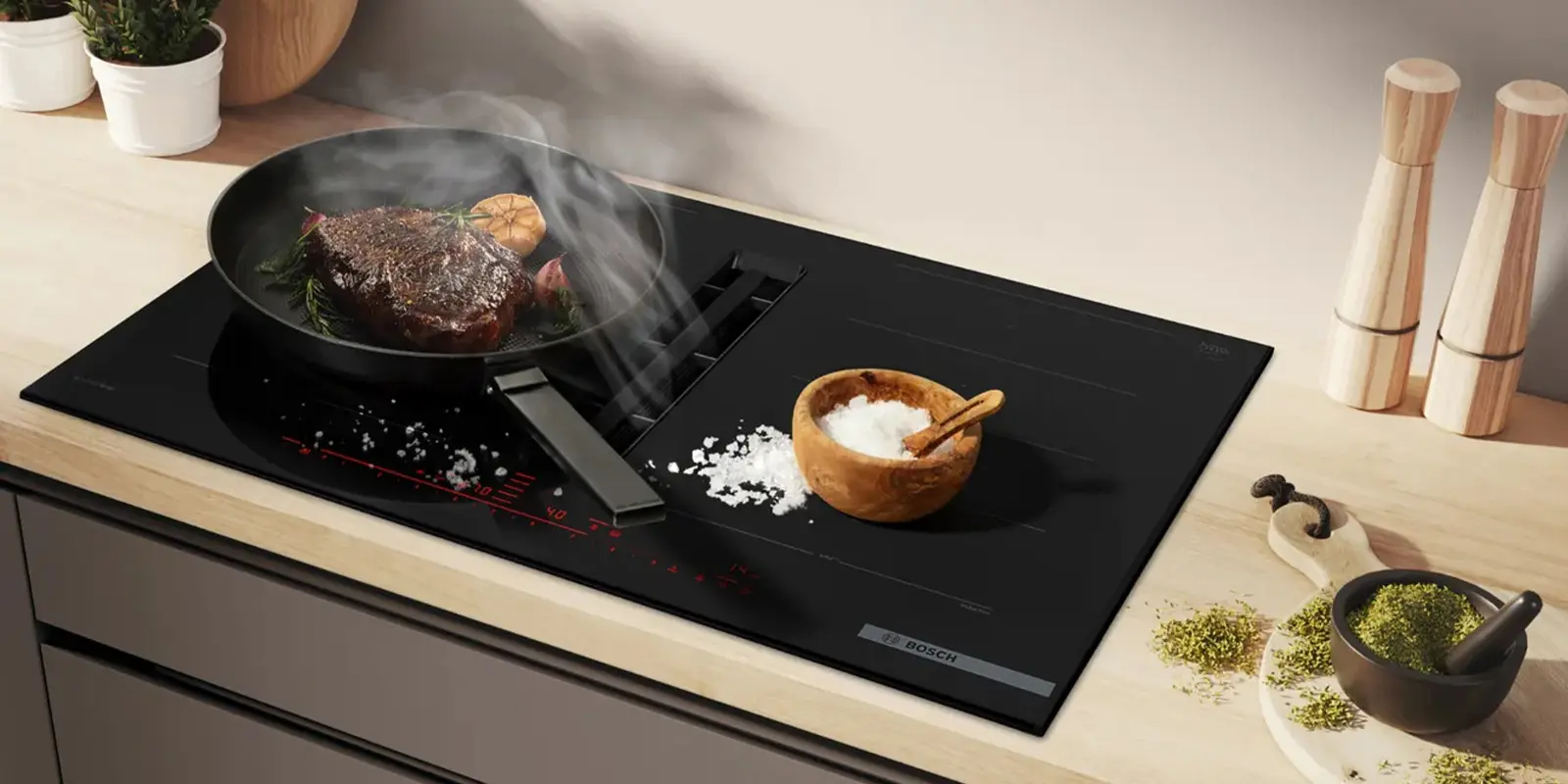 Kochfeld von Bosch, das die Funktion zeigt, eine eingebaute Dunstabzugshaube zu haben, die beim Kochen den entstehenden Dampf direkt abzieht.&nbsp;