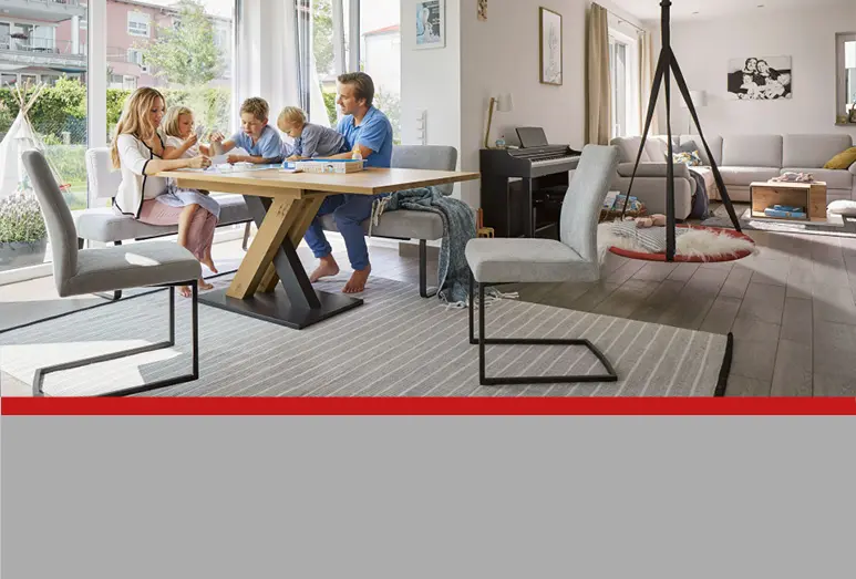 Familie am Esstisch im schönen gemütlichen Wohnzimmer