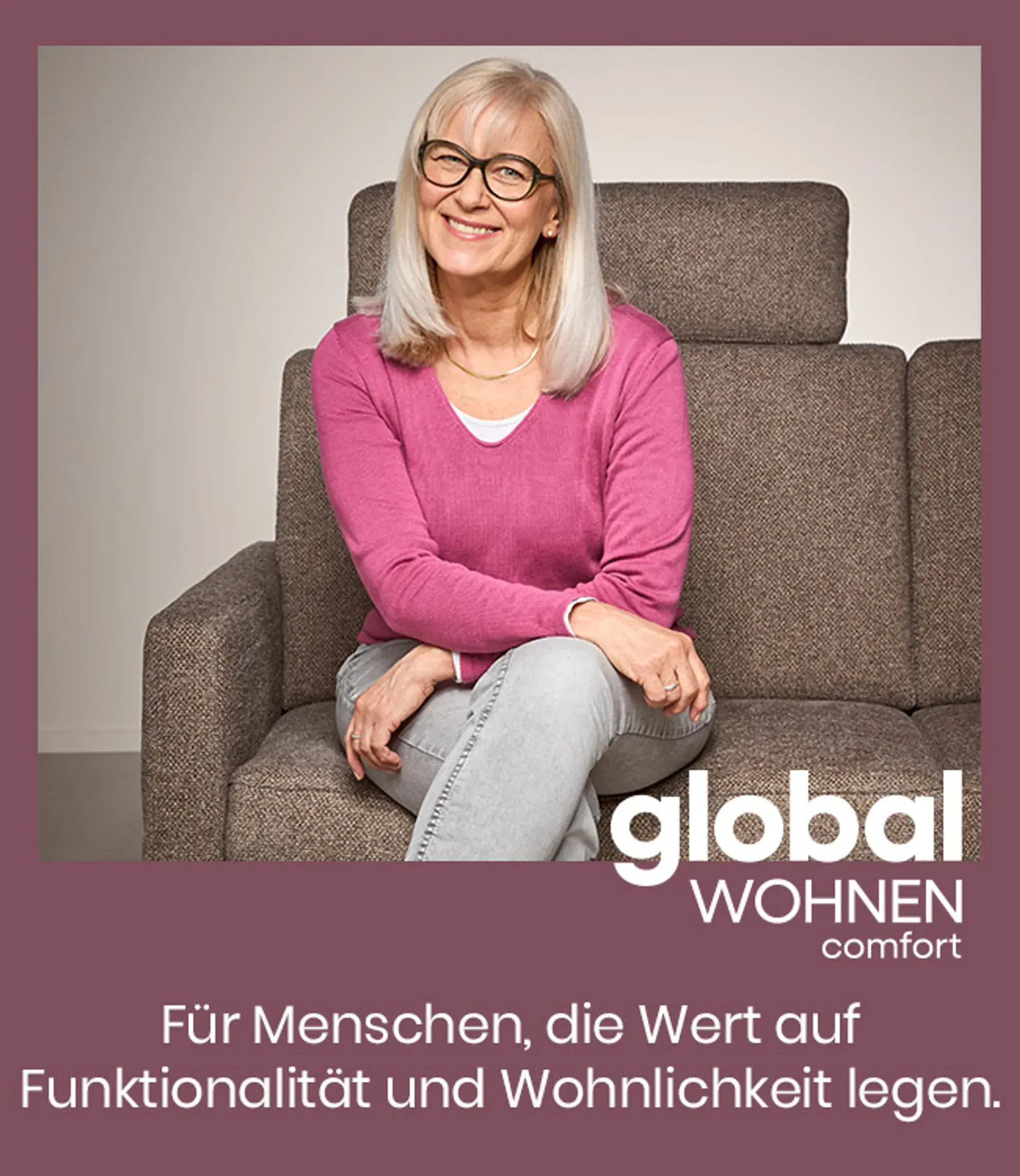 Ältere Frau sitzt lächelnd auf einem Polstersofa der Linie Global Wohnen Comfort und zeigt komfortable Sitzmöbel mit hoher Funktionalität und wohnlichem Design für modernes Wohnzimmer.
