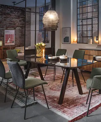 Esszimmer mit robustem Esstisch und samtbezogenen Stühlen.