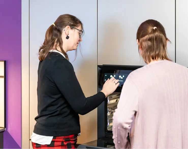 Mitarbeiterin von Kuechenhaus Gruber beraet Kundin vor Einbauofen