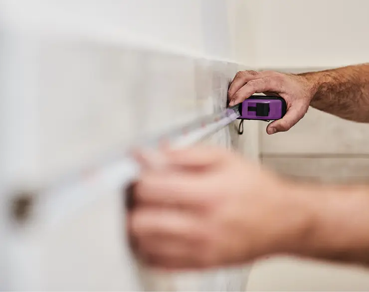 Aufmass einer Kueche mit lilafarbenem Massband