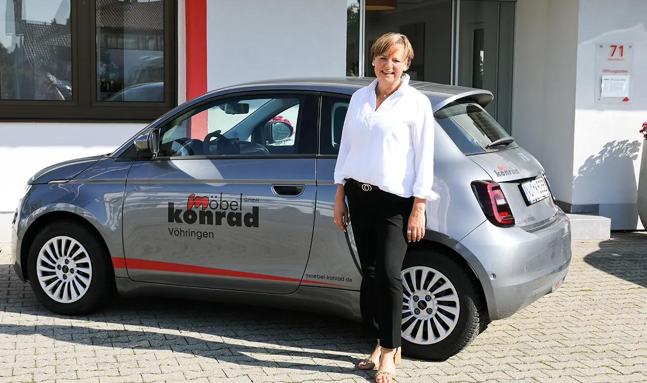 Frau steht vor einem Service-Auto des Möbelhauses