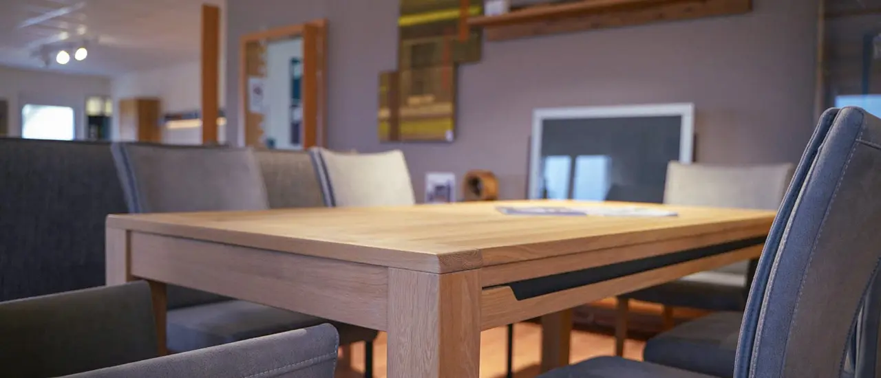 Hölzerner Esstisch mit modischen grauen Stühlen