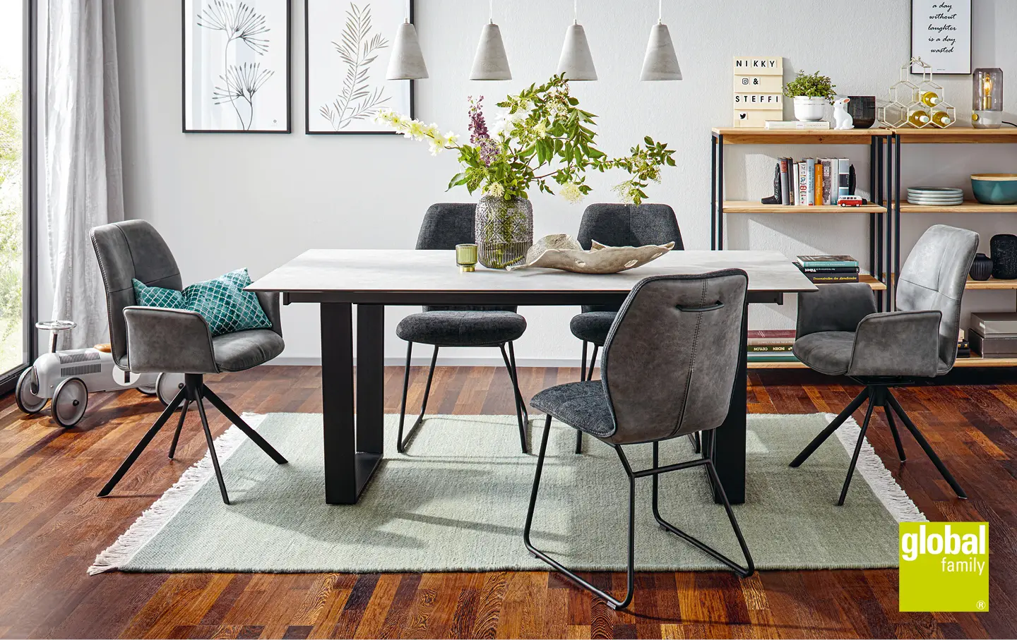 Stylischer Esstisch mit Metallfuessen und grauen gepolsterten Stuehlen in hellem Esszimmer