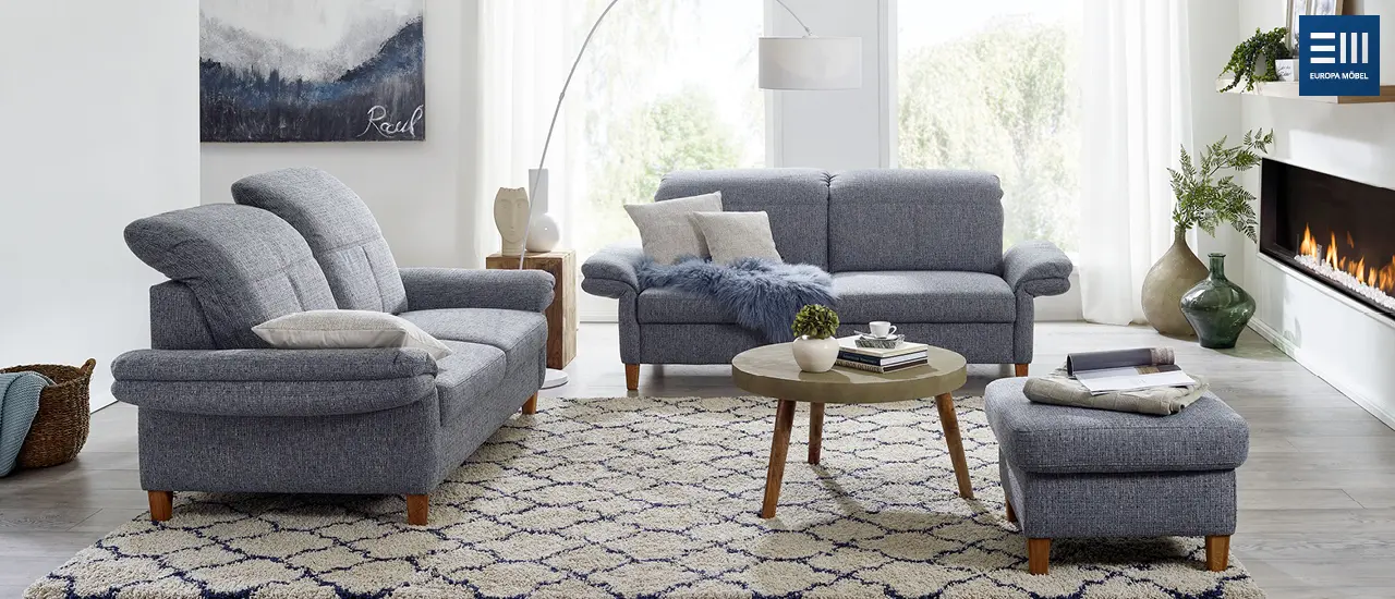Europa Möbel-Collection - Grau-blaue Polstersofas in gemütlichem Wohnzimmer mit Kamin