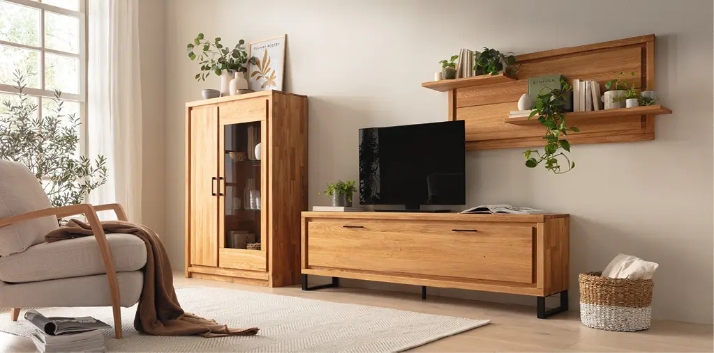 Helles Wohnzimmer mit Massivholzmöbeln aus Eiche, TV Lowboard, Vitrine und Wandregal, kombiniert mit Pflanzen, Sofa und Teppich für ein modernes, natürliches Wohnambiente mit warmen Farben