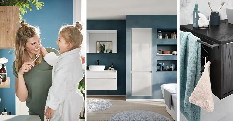 Mutter mit Tochter im Bad beim Zähneputzen, weiße Badmöbel vor blauer Badezimmerwand, blaues Handtuch am dunklen Holzsideboard im Bad