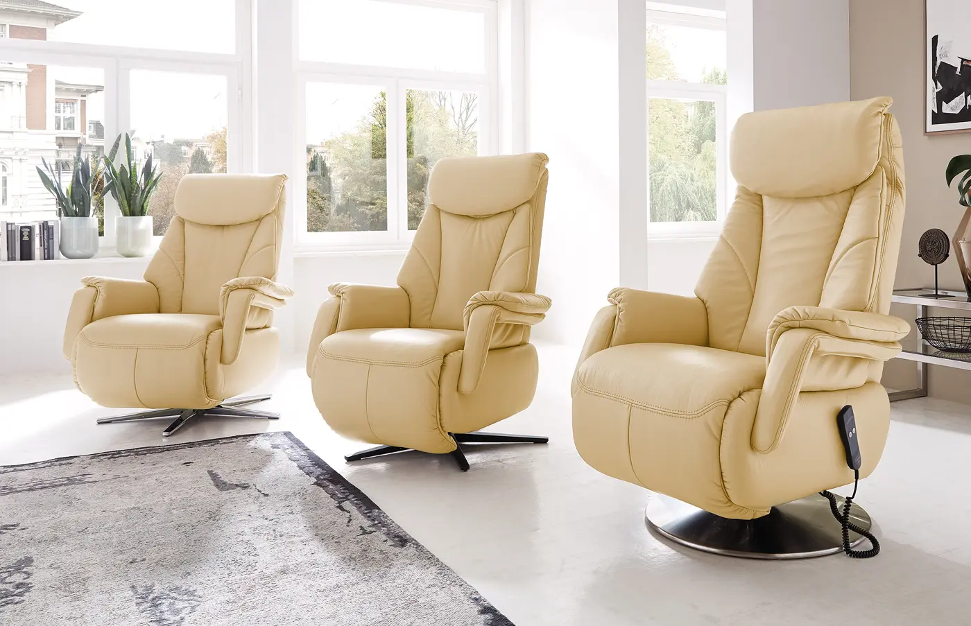 Drei gelbe Relaxsessel mit unterschiedlichen Fußgestellen in einem hellen Raum.