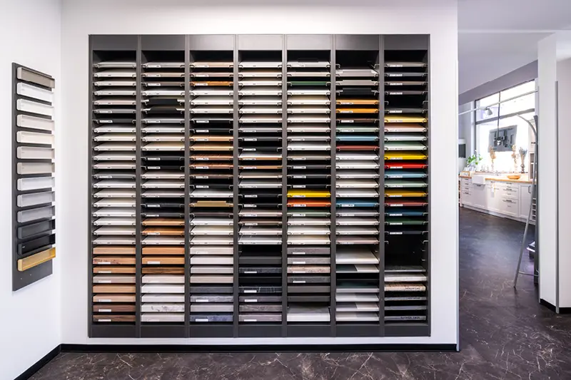 Regal mit gut sortierten Materialmustern fuer die Kuechenplanung