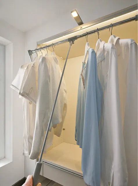 Kleiderlift mit Hemden an Kleiderstange im begehbaren Kleiderschrank