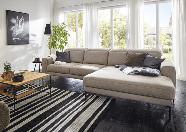 Graubraunes Stoff-Ecksofa in hellem Wohnzimmer