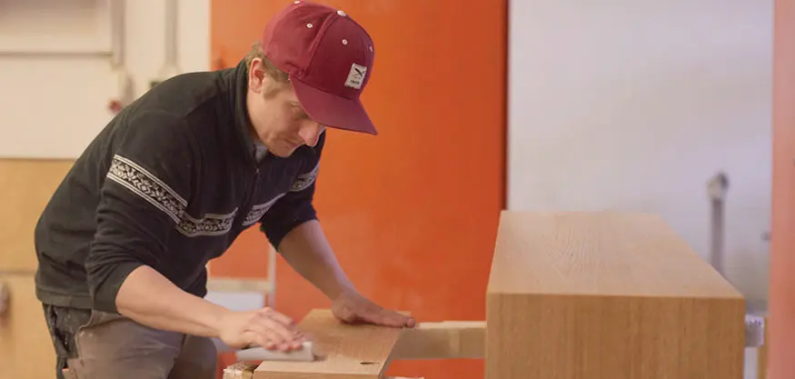 Schreiner Peißenberg streicht über Holzplatte