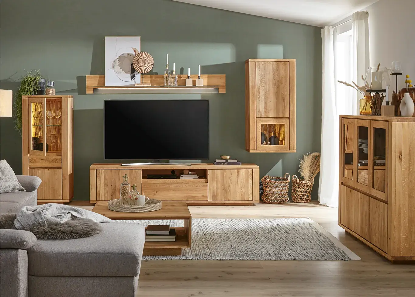 Wohnzimmer mit Wohnwand aus Massivholz, TV Lowboard, Vitrine und Wandregal. Moderne Wohnzimmermöbel aus Holz mit natürlicher Oberfläche und stilvoller Dekoration