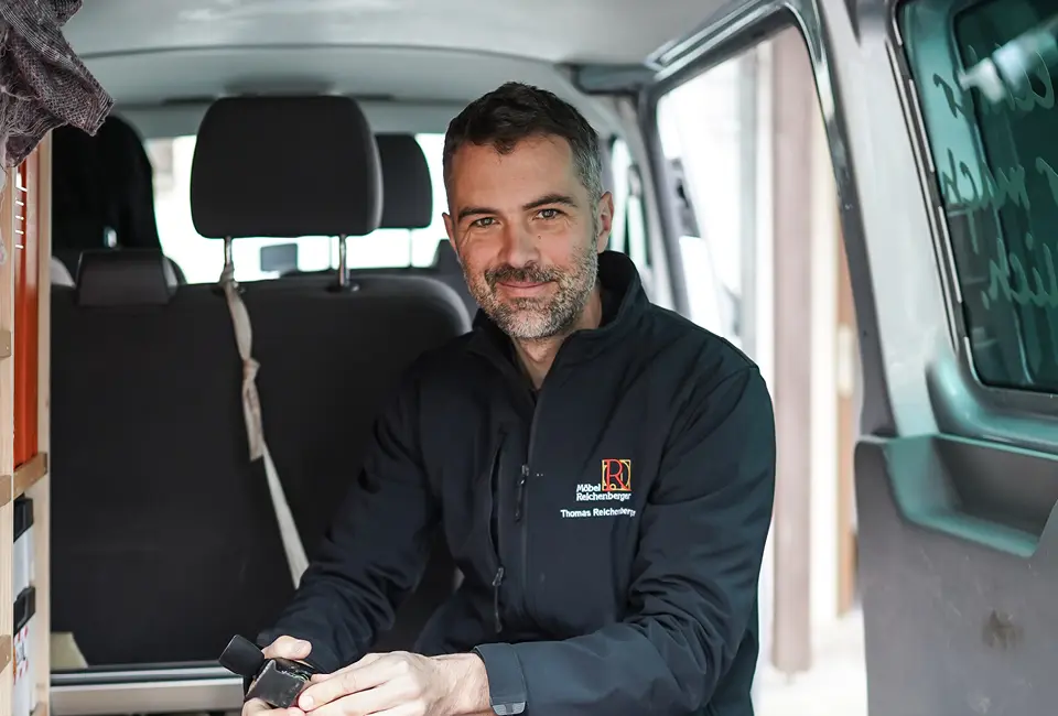 Mitarbeiter aus dem Team von Möbel Reichenberger im Lieferwagen auf dem Weg zum Kundendienst