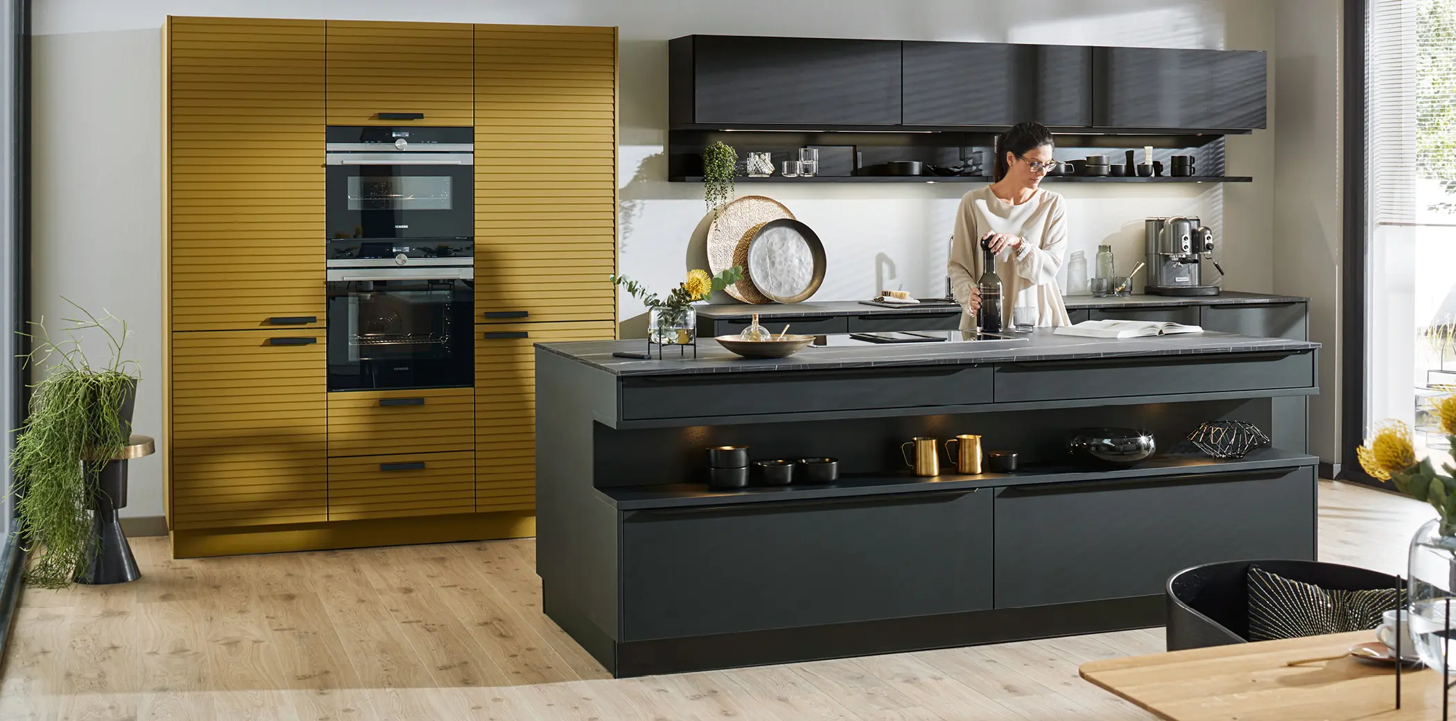 Moderne Wohnküche mit dunklen Fronten und auffälligen Hochschränken rund um den Backofen