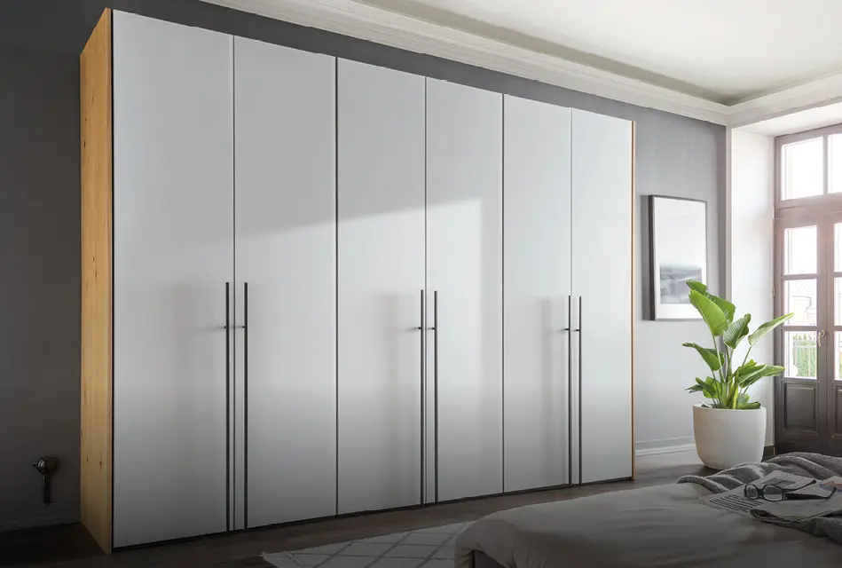 Großer Kleiderschrank mit weißen Türen und Holzseiten im Schlafzimmer
