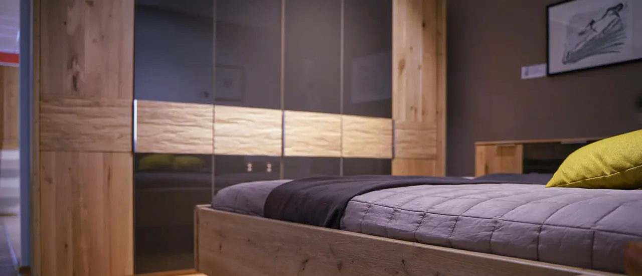 Hölzernes Bett und Kleiderschrank in Schlafzimmer