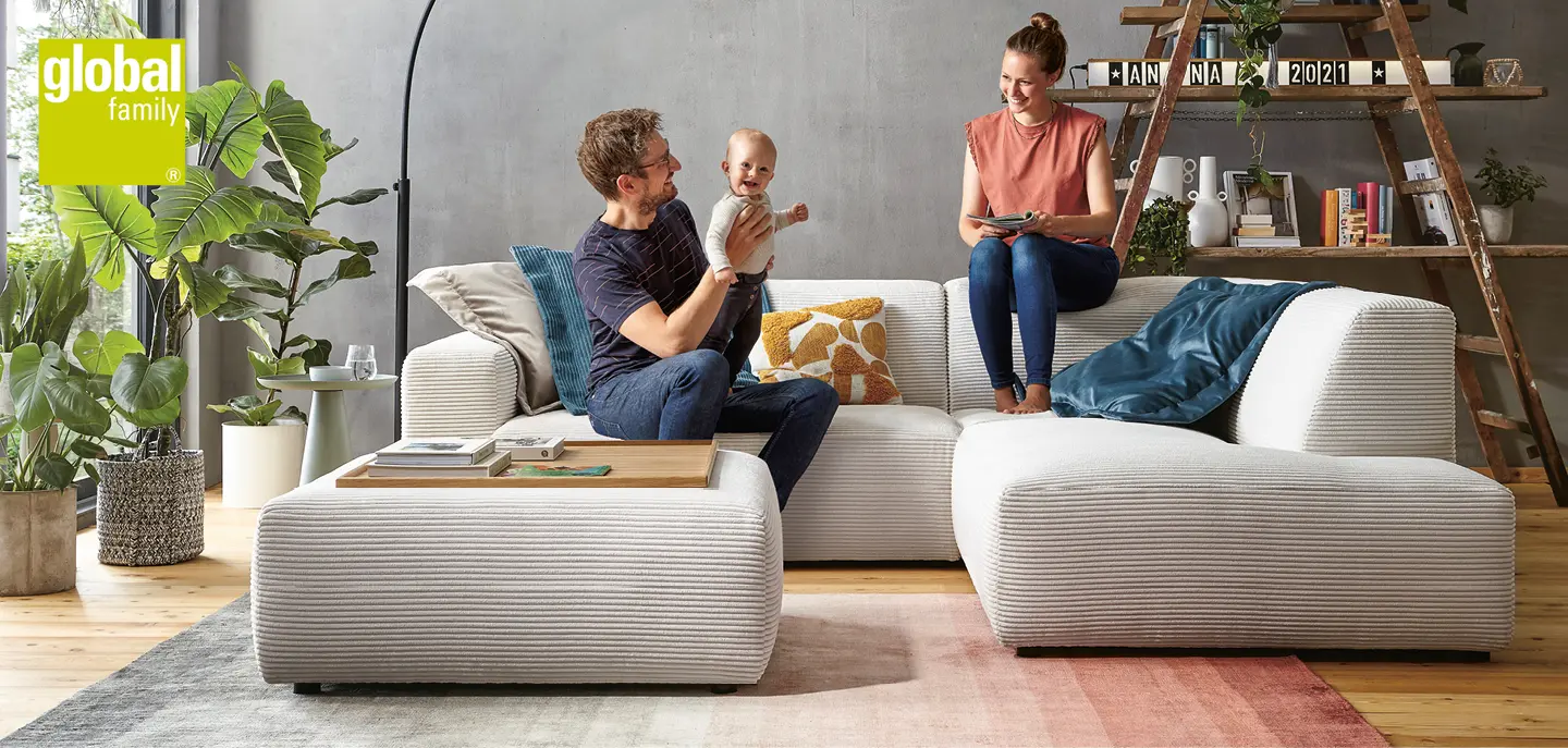 Eltern mit Baby auf weissem Sofa