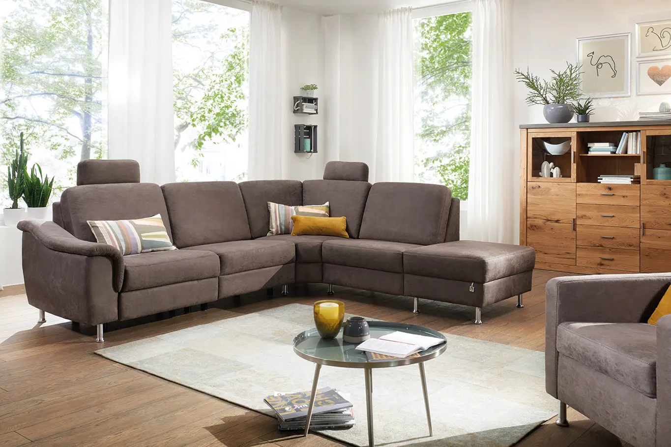 Braunes Ecksofa mit passendem Sessel in gemuetlich eingerichtetem Wohnzimmer