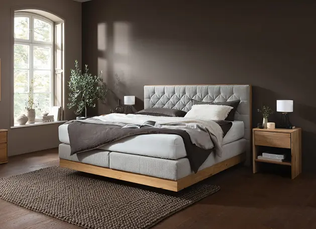 Gepolstertes Doppelbett mit Nachttischen im modernen Schlafzimmer