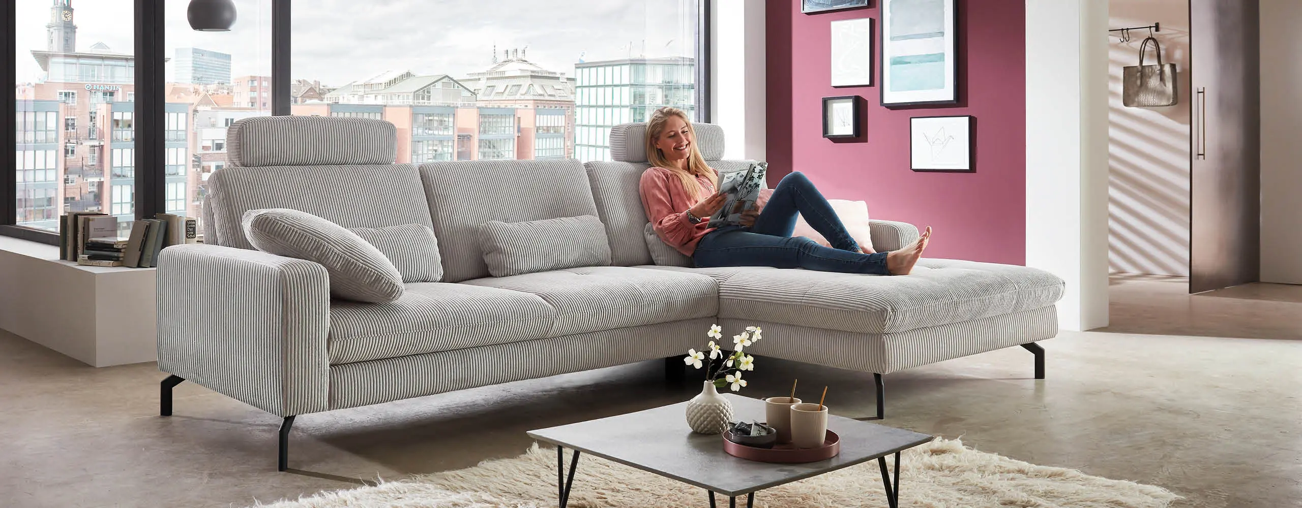 Stoff Sofaecke hellgrau mit Frau darauf liegend