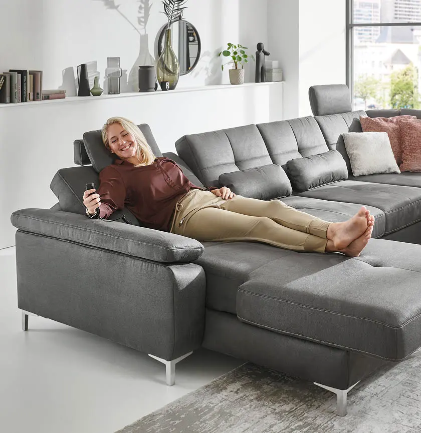 Frau liegt auf grauen Sofa