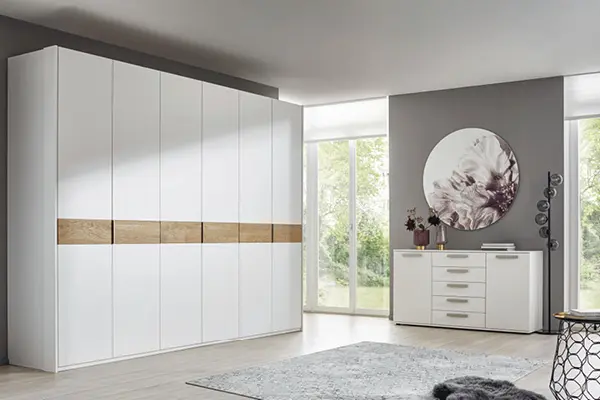 Glatte Oberflächen und natürliche Optik durch Elemente aus Holz machen den Kleiderschrank im modernen Schlafzimmer zu einem Highlight.