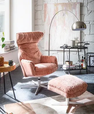Ein rosafarbener Sessel mit Samtüberzug.