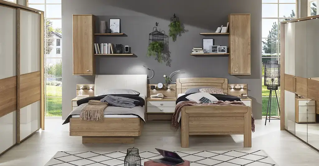 Holzbett mit weißer Bettwäsche, großen Kleiderschränken und dunkler Wand