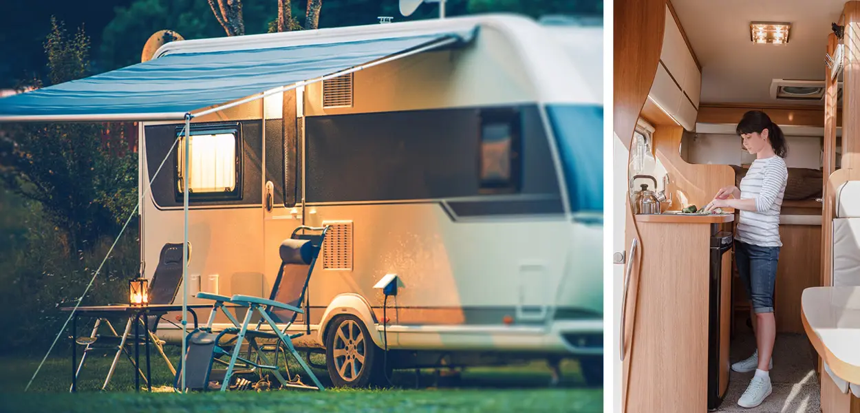 Wohnwagen mit Vordach vor einem Wald, davor ein Tisch mit zwei Stühlen, Frau im Wohnwageninneren