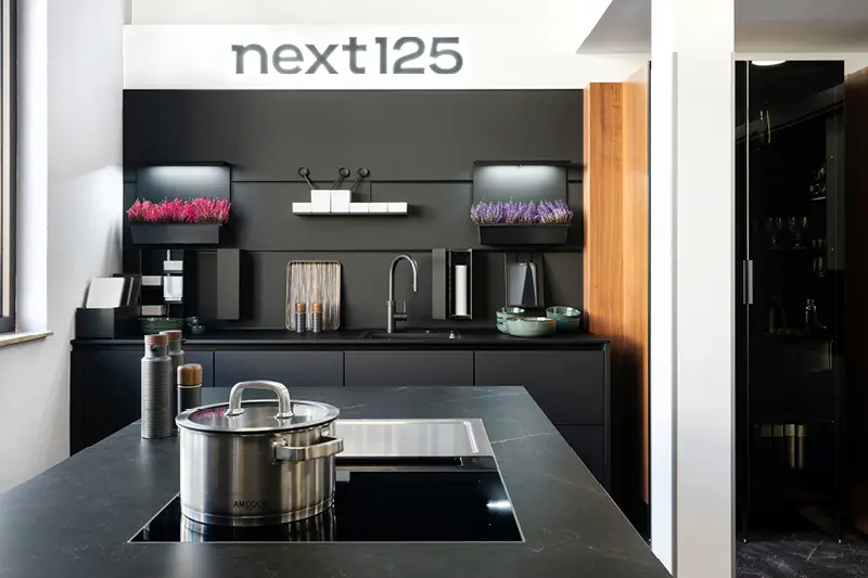 Anthrazitfarbene Inselkueche mit Holzelementen im Kuechenhaus Gruber