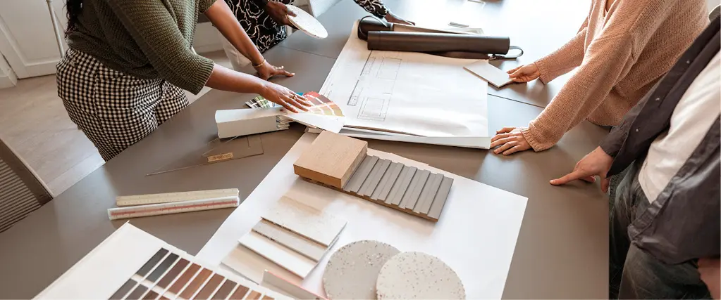 Beratungssituation bei der Möbelplanung mit Farbmustern, Holzproben und Materialmustern auf einem Tisch für individuelle Küchen und Einrichtungskonzepte.