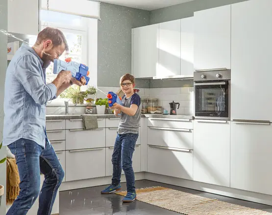 Vater mit Sohn spielend in Küche