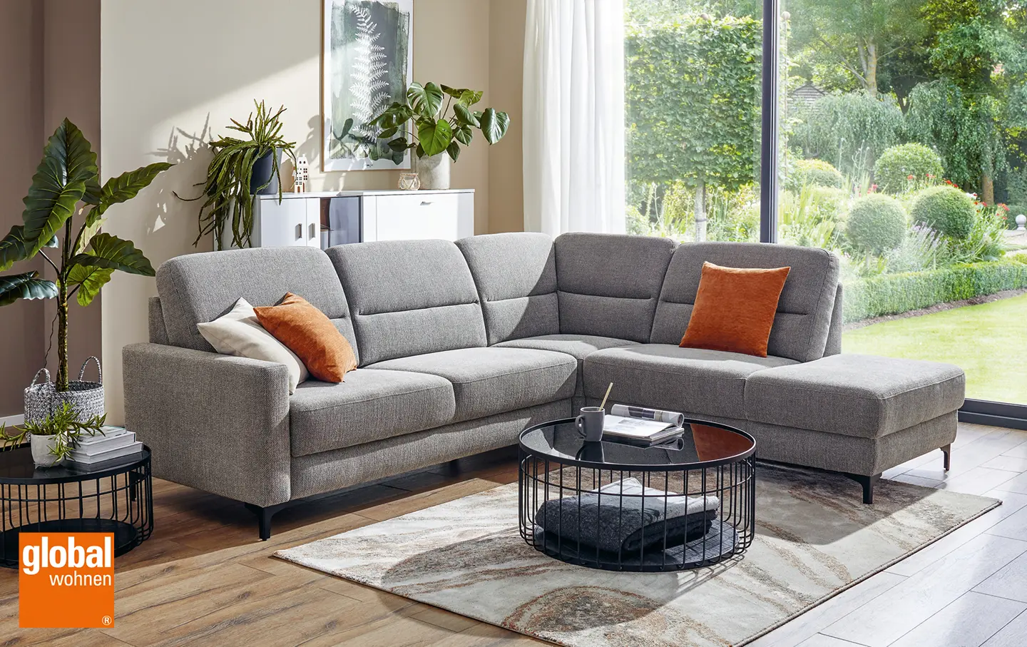 Hellgraues Sofa mit orangefarbenen Kissen in modernem Wohnzimmer