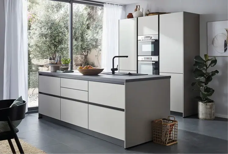 Moderne Küche mit heller Kochinsel, Spüle und Backofen am Fenster